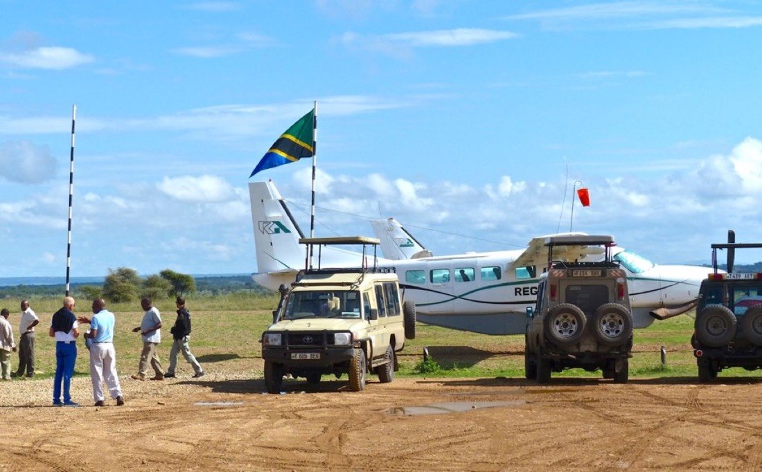 Light aircraft and safari vehicles waiting on the Seronera airstrip in the Serengeti