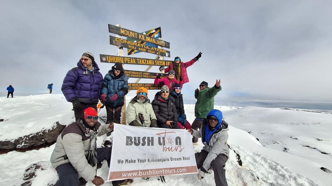 Kilimanjaro climbers at Uhuru Peak summit with dramatic sky